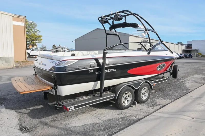 Slide: The Image of 2004 Malibu Wakesetter 23 XTi boat on trailer, parked outdoors. - 6