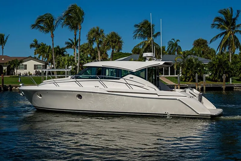 Slide: The Image of 2018 Tiara Yachts C39 Coupe cruising on a sunny day with palm trees in background. - 10