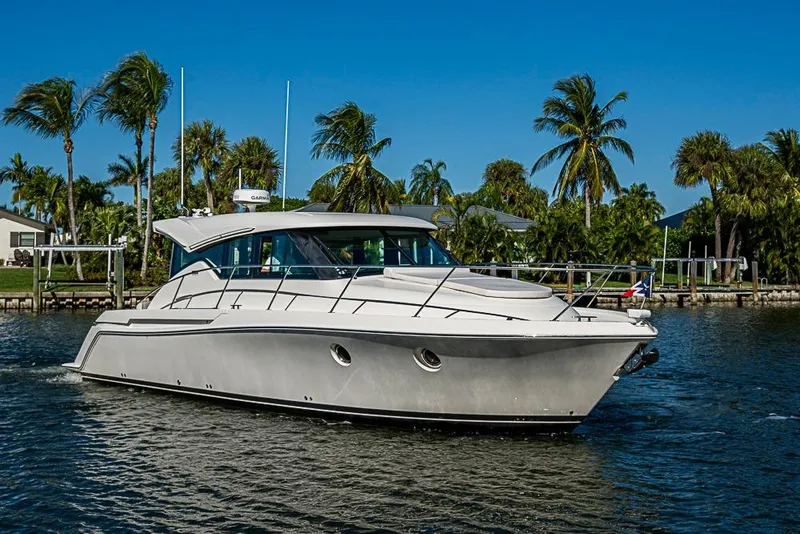 Slide: The Image of 2018 Tiara Yachts C39 Coupe cruising on a sunny day with palm trees in the background. - 12