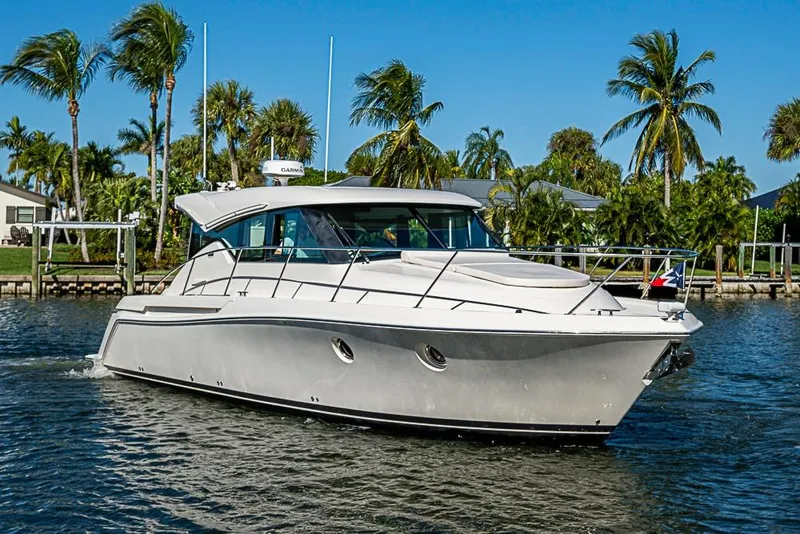 Slide: The Image of 2018 Tiara Yachts C39 Coupe cruising on a sunny day with palm trees in the background. - 13