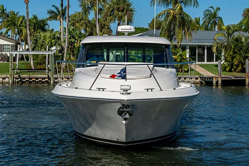 Slide: The Image of 2018 Tiara Yachts C39 Coupe on water, surrounded by palm trees and waterfront homes. - 14