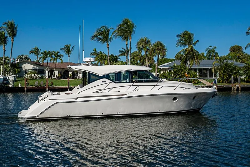 Slide: The Image of 2018 Tiara Yachts C39 Coupe cruising on a sunny day with palm trees in the background. - 18