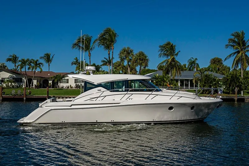 Slide: The Image of 2018 Tiara Yachts C39 Coupe cruising on a sunny day with palm trees in the background. - 19