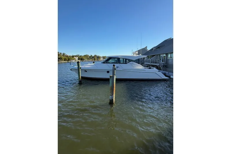 Slide: The Image of 2018 Tiara Yachts C39 Coupe cruising on a sunny day with palm trees in the background. - 2
