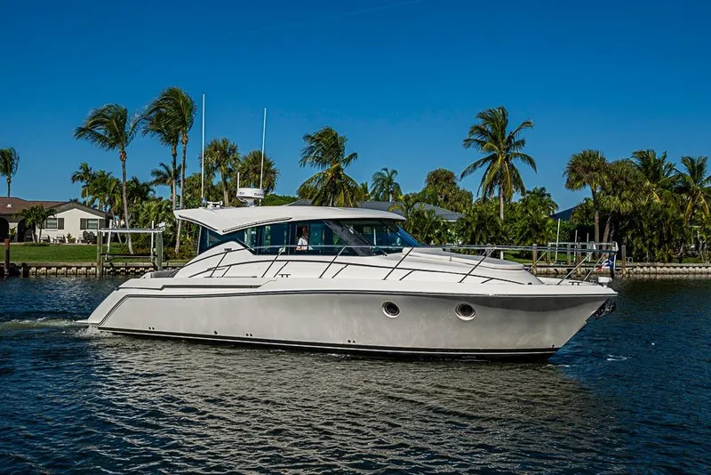 Slide: The Image of 2018 Tiara Yachts C39 Coupe cruising on a sunny day with palm trees in the background. - 22
