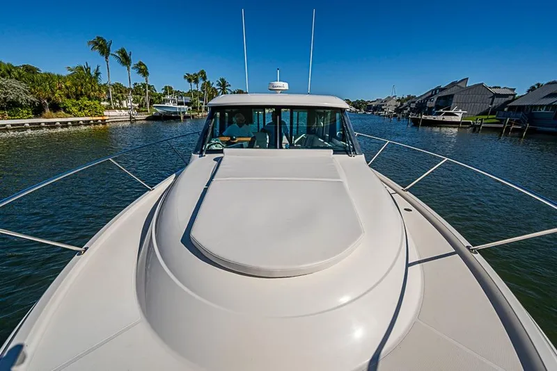 Slide: The Image of 2018 Tiara Yachts C39 Coupe cruising on a sunny waterway with palm trees. - 24