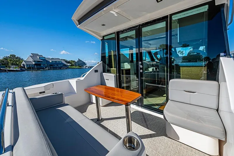 Slide: The Image of 2018 Tiara Yachts C39 Coupe with outdoor seating and scenic waterfront view. - 32