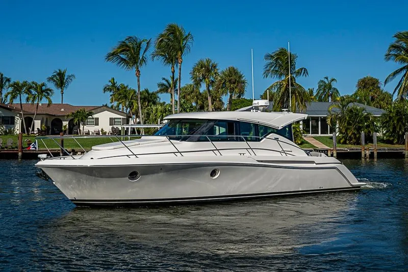 Slide: The Image of 2018 Tiara Yachts C39 Coupe cruising on a sunny day, surrounded by palm trees. - 8