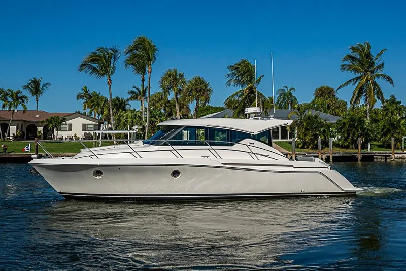 Slide: The Image of 2018 Tiara Yachts C39 Coupe cruising on a sunny day with palm trees in the background. - 9