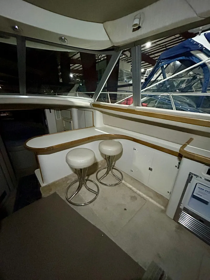 Slide: The Image of Interior of 1996 Sea Ray 370 Sedan Bridge with bar stools. - 11
