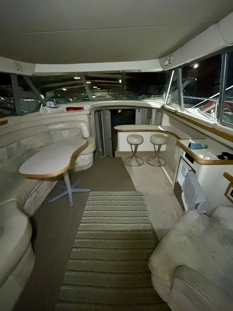 Slide: The Image of Interior of 1996 Sea Ray 370 Sedan Bridge, featuring seating area and table. - 20
