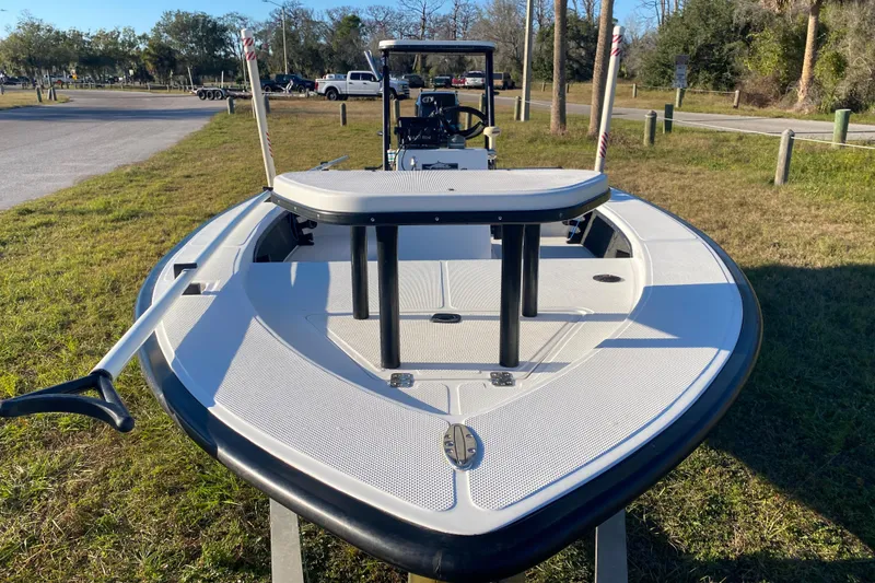 Slide: The Image of 1999 Silver King Signature 16 boat on grass, showcasing deck and motor. - 19