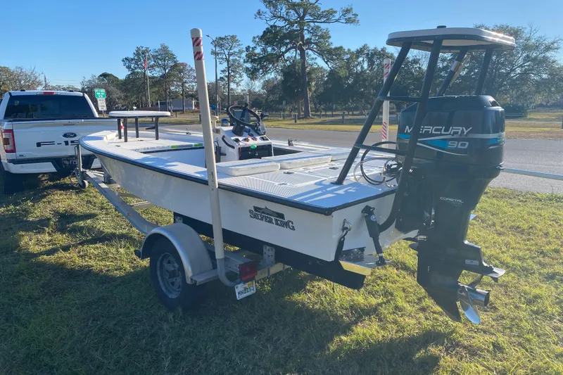 Slide: The Image of 1999 Silver King Signature 16 boat on trailer, parked near trucks and other boats. - 4