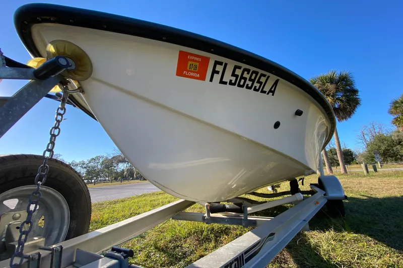 Slide: The Image of 1999 Silver King Signature 16 boat underside on trailer, grassy outdoor setting. - 8