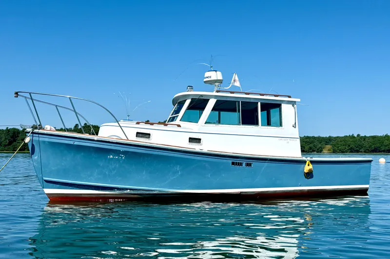 The Image of 1985 Cape Dory 28 Power Yacht on calm water under clear blue sky. - 0