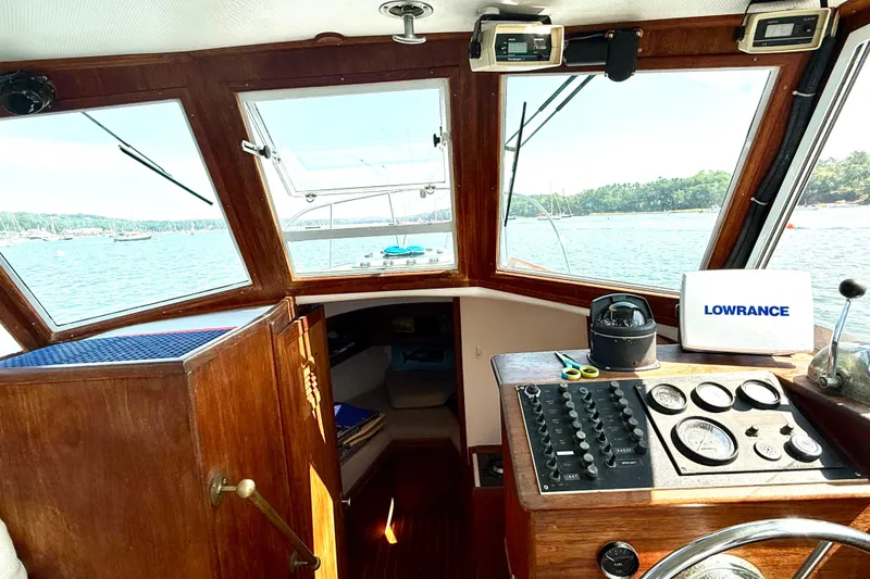 Slide: The Image of 1985 Cape Dory 28 Power Yacht interior with navigation equipment and scenic water view. - 11