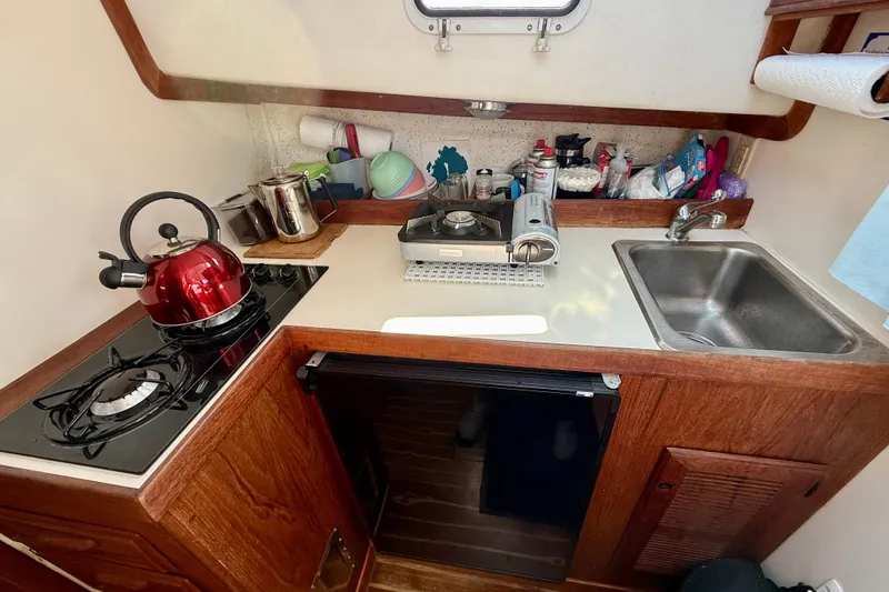 Slide: The Image of Compact kitchen in 1985 Cape Dory 28 Power Yacht with stove, sink, and red kettle. - 12