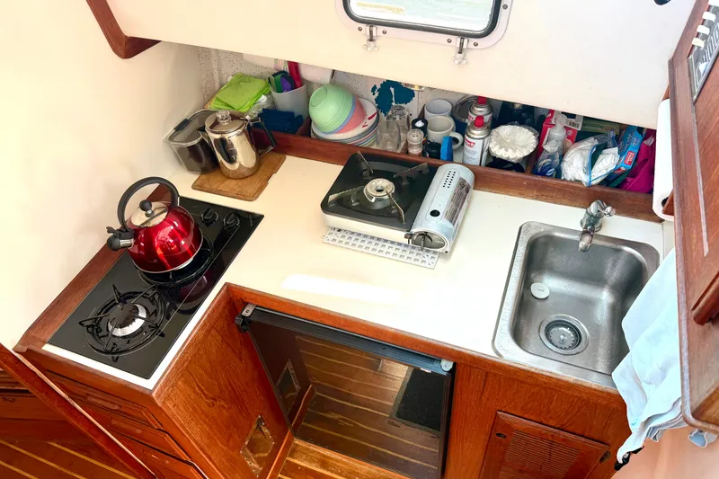 Slide: The Image of Compact kitchen in 1985 Cape Dory 28 Power Yacht with stove, sink, and red kettle. - 13