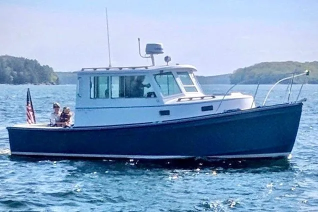Slide: The Image of 1985 Cape Dory 28 Power Yacht cruising on a sunny day with passengers onboard. - 3