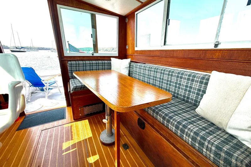 Slide: The Image of Interior of 1985 Cape Dory 28 Power Yacht with wooden table and plaid seating. - 6