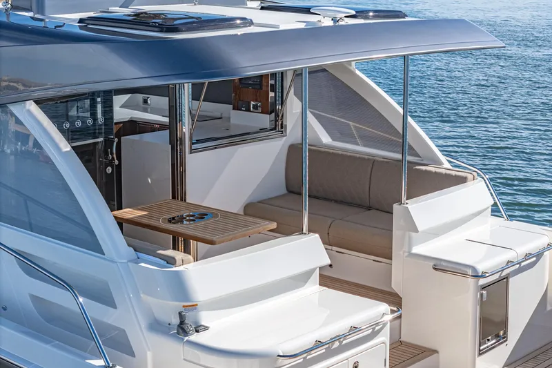 Slide: The Image of 2024 Riviera 465 SUV luxury yacht with outdoor seating and table. - 22