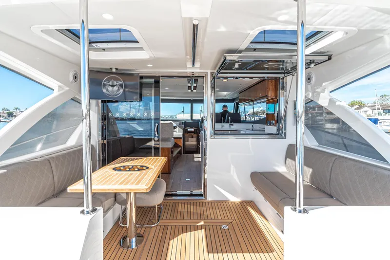 Slide: The Image of 2024 Riviera 465 SUV luxury yacht interior with seating, table, and modern amenities. - 24