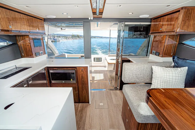 Slide: The Image of 2024 Riviera 465 SUV interior with modern kitchen and seating area, overlooking the water. - 26