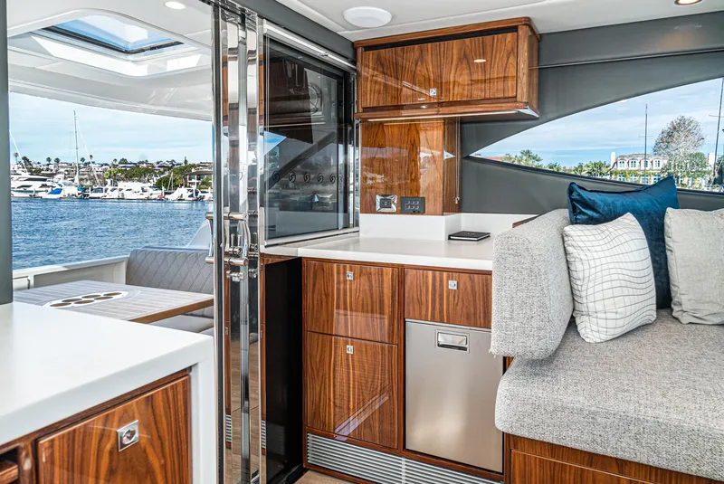 Slide: The Image of 2024 Riviera 465 SUV yacht interior with modern kitchen and waterfront view. - 28