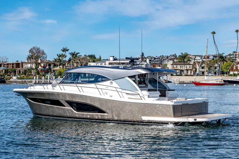 Slide: The Image of 2024 Riviera 465 SUV luxury yacht cruising in a scenic marina. - 3