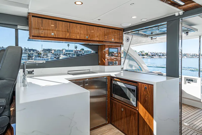 Slide: The Image of 2024 Riviera 465 SUV yacht kitchen with modern appliances and waterfront view. - 31