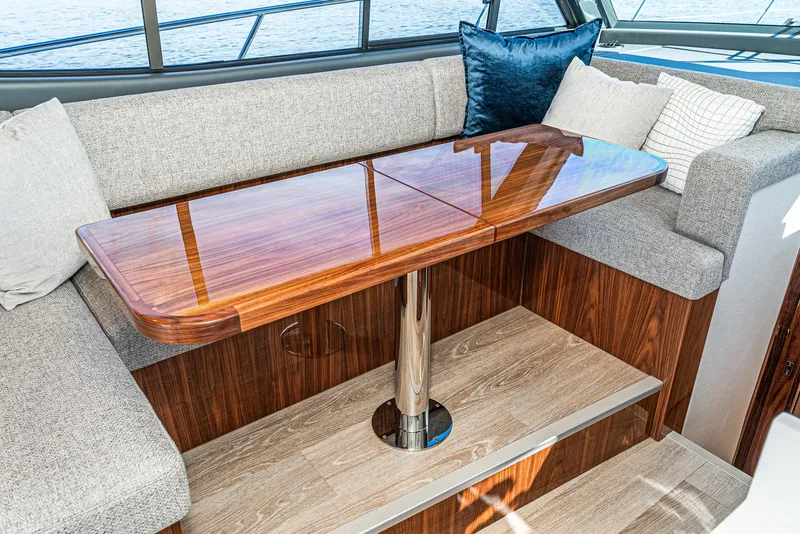 Slide: The Image of Luxurious interior seating area of 2024 Riviera 465 SUV with wooden table and plush cushions. - 33