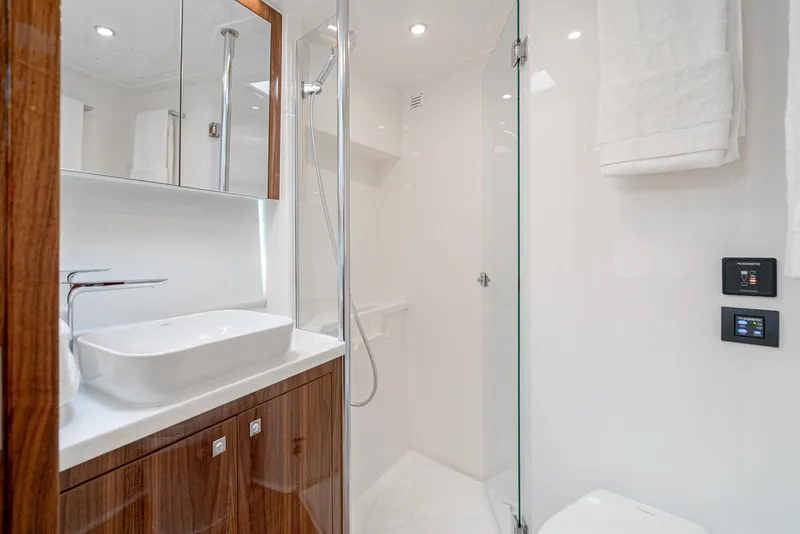 Slide: The Image of Luxurious bathroom in 2024 Riviera 465 SUV yacht with modern fixtures and wooden cabinetry. - 38