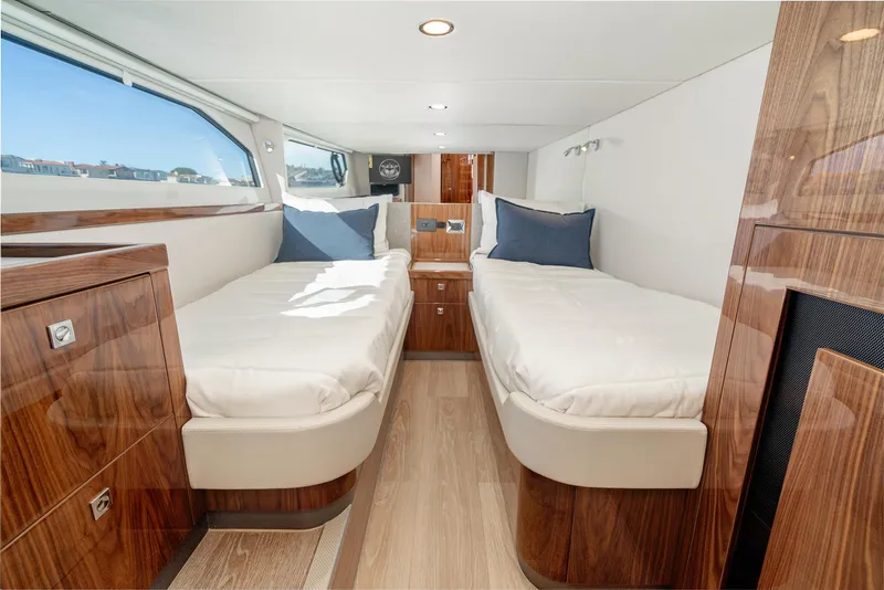 Slide: The Image of 2024 Riviera 465 SUV twin bed cabin with modern wood finish and large window. - 40