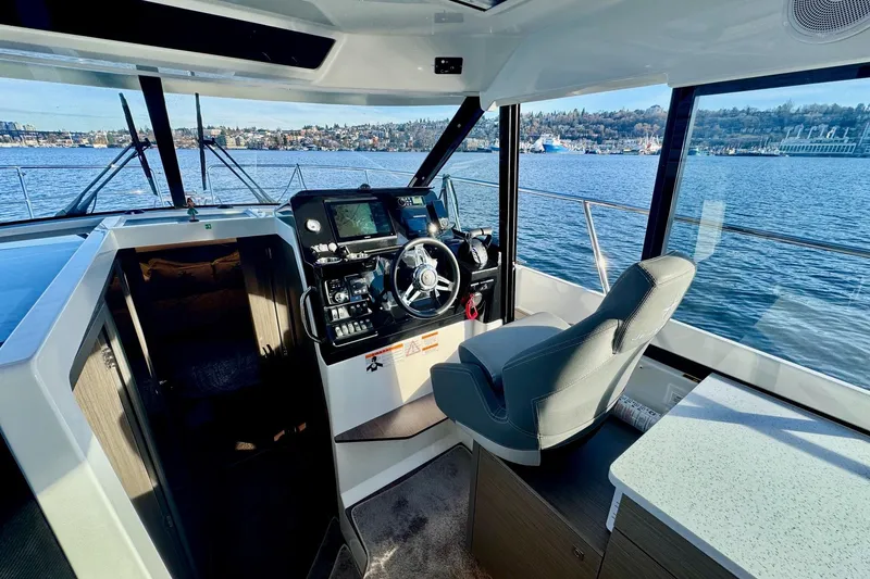 Slide: The Image of 2024 Jeanneau NC 1095 Coupe Series 2 helm with panoramic water view. - 11