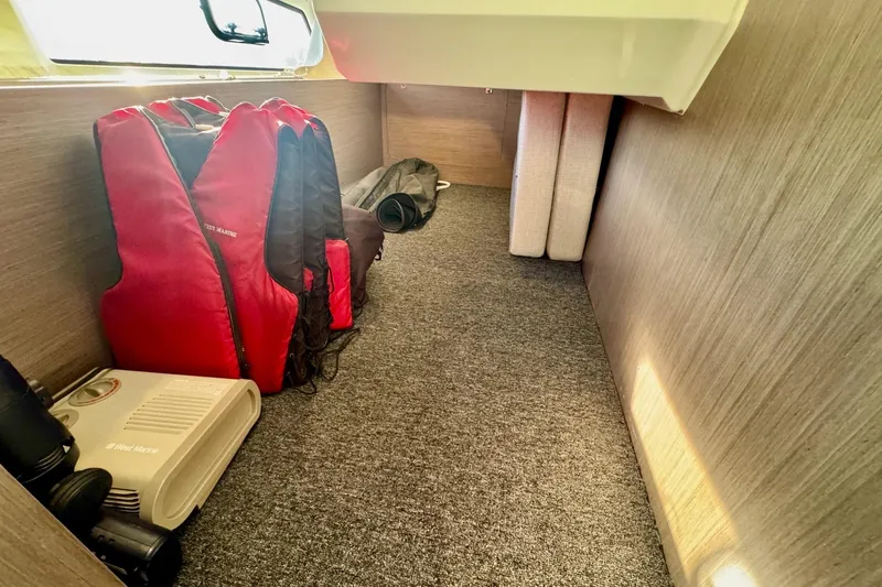 Slide: The Image of 2024 Jeanneau NC 1095 Coupe Series 2 cabin storage with life jackets and equipment. - 18