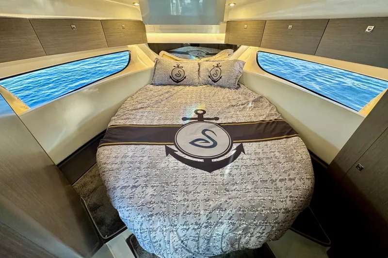 Slide: The Image of 2024 Jeanneau NC 1095 Coupe Series 2 cabin with nautical-themed bedding and ocean view. - 20