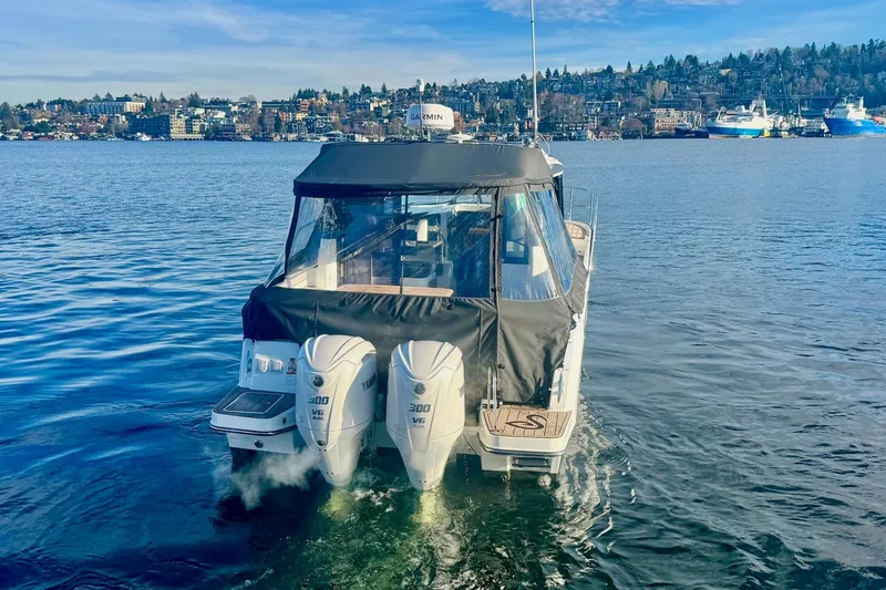Slide: The Image of 2024 Jeanneau NC 1095 Coupe Series 2 boat on calm water with twin Yamaha engines. - 6