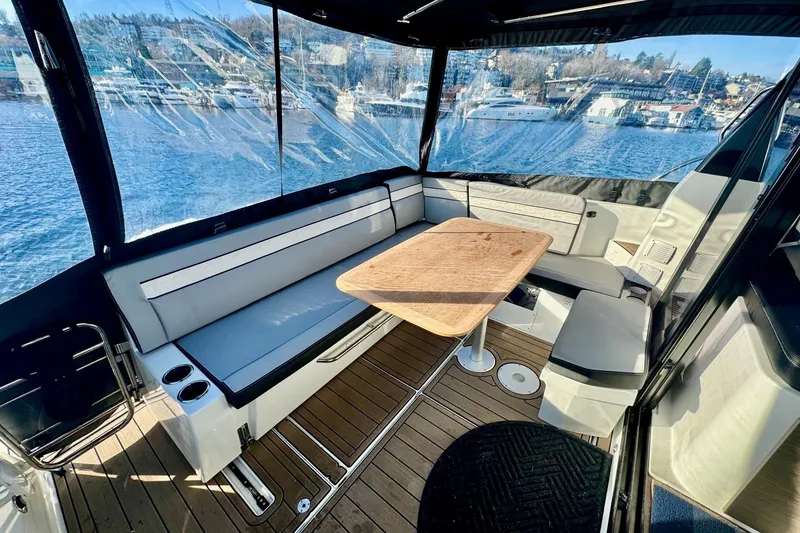 Slide: The Image of 2024 Jeanneau NC 1095 Coupe Series 2 boat interior with seating and table, overlooking water. - 7