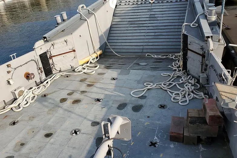 Slide: The Image of 1970 COMMERICAL BOAT LCU-135 deck with ropes and equipment, docked by water. - 3