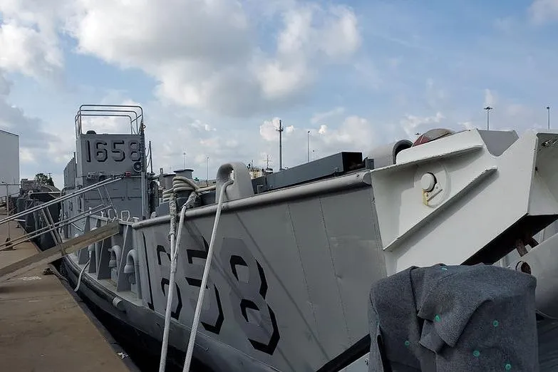 Slide: The Image of 1970 COMMERICAL BOAT LCU-135 docked, displaying hull number 1658 under cloudy sky. - 5