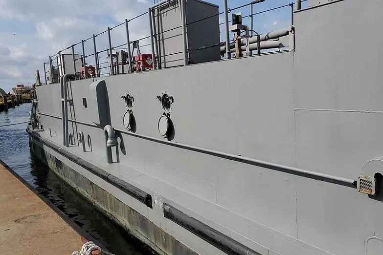 Slide: The Image of 1970 COMMERICAL BOAT LCU-135 docked at a harbor, side view. - 8