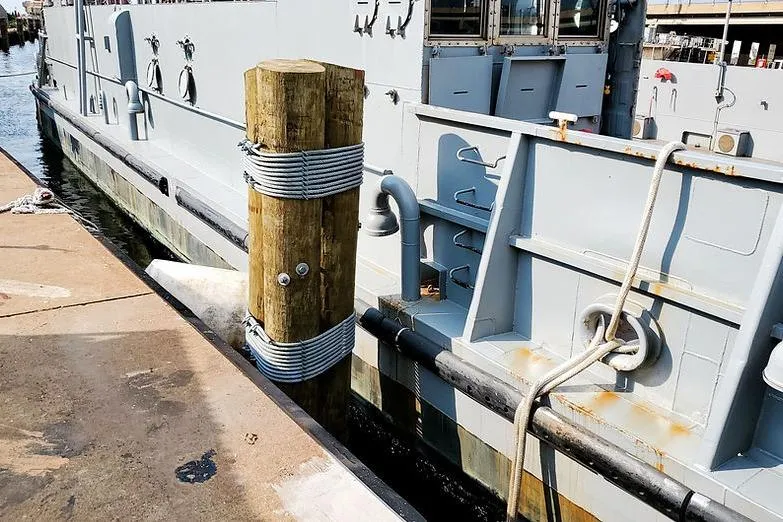 Slide: The Image of 1970 COMMERICAL BOAT LCU-135 docked, showing side view with mooring post. - 9