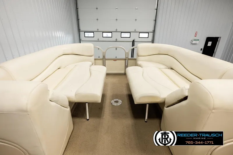 Slide: The Image of 2006 Sun Tracker Party Barge 22 Regency Edition with cream seating in a garage. - 18