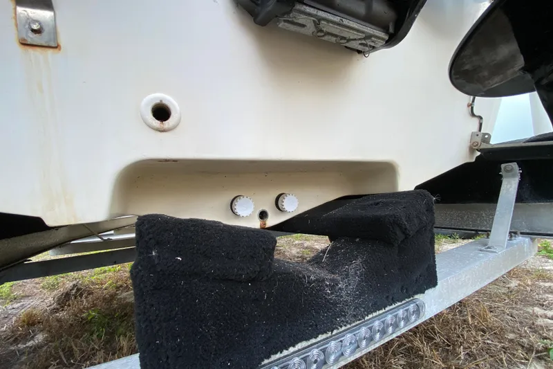 Slide: The Image of 2006 Mako 191 Inshore boat on trailer, showing hull and drain plugs. - 13