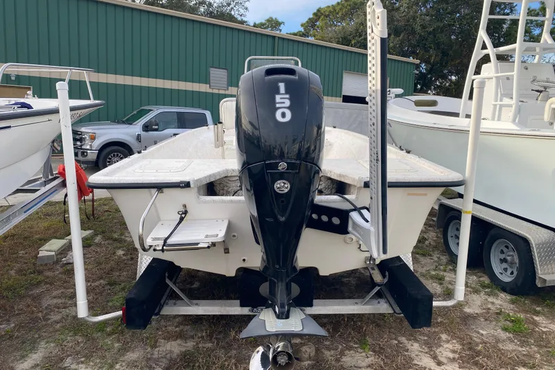 Slide: The Image of 2006 Mako 191 Inshore boat with 150 HP engine, parked outdoors. - 2