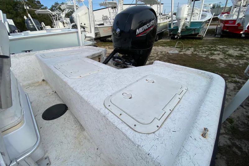Slide: The Image of 2006 Mako 191 Inshore boat with Mercury outboard engine, parked among other boats. - 23