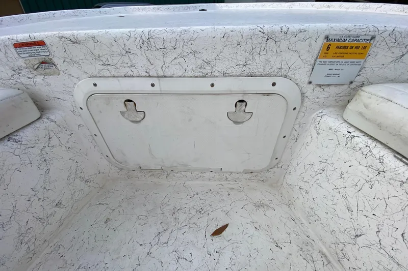 Slide: The Image of 2006 Mako 191 Inshore boat interior with storage hatch and capacity label. - 34