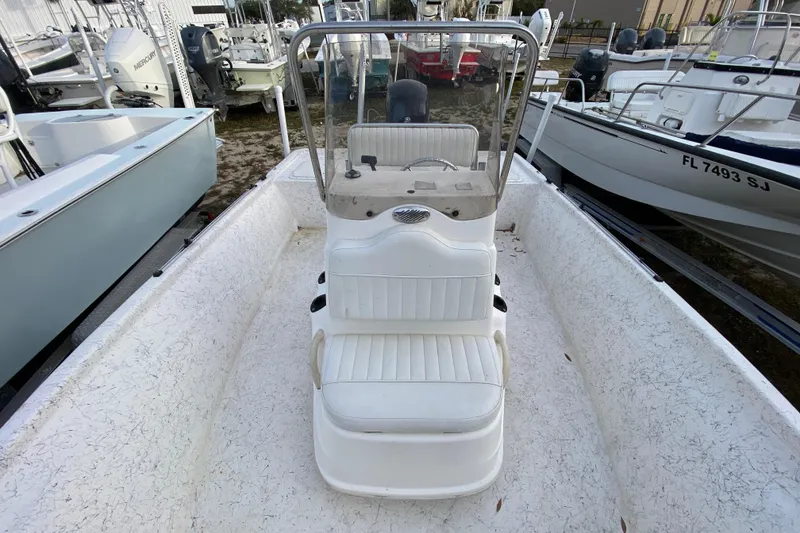 Slide: The Image of 2006 Mako 191 Inshore boat with center console and white seating, docked among other boats. - 36