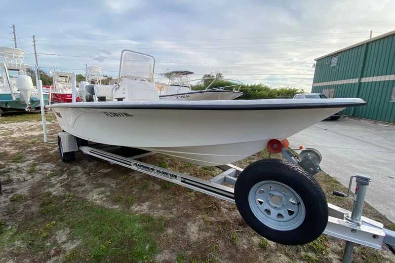 Slide: The Image of 2006 Mako 191 Inshore boat on trailer, parked outdoors near green building. - 4