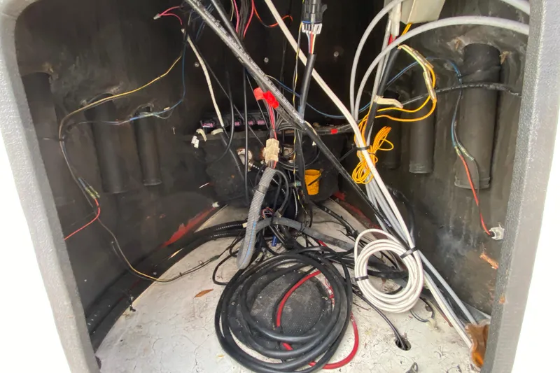 Slide: The Image of Tangled wiring inside a 2006 Mako 191 Inshore boat compartment. - 48